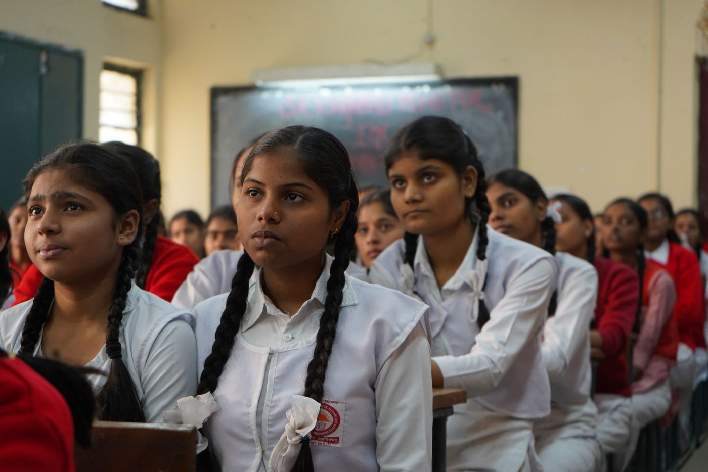 Schoolgirls in uniform listening in a classroom